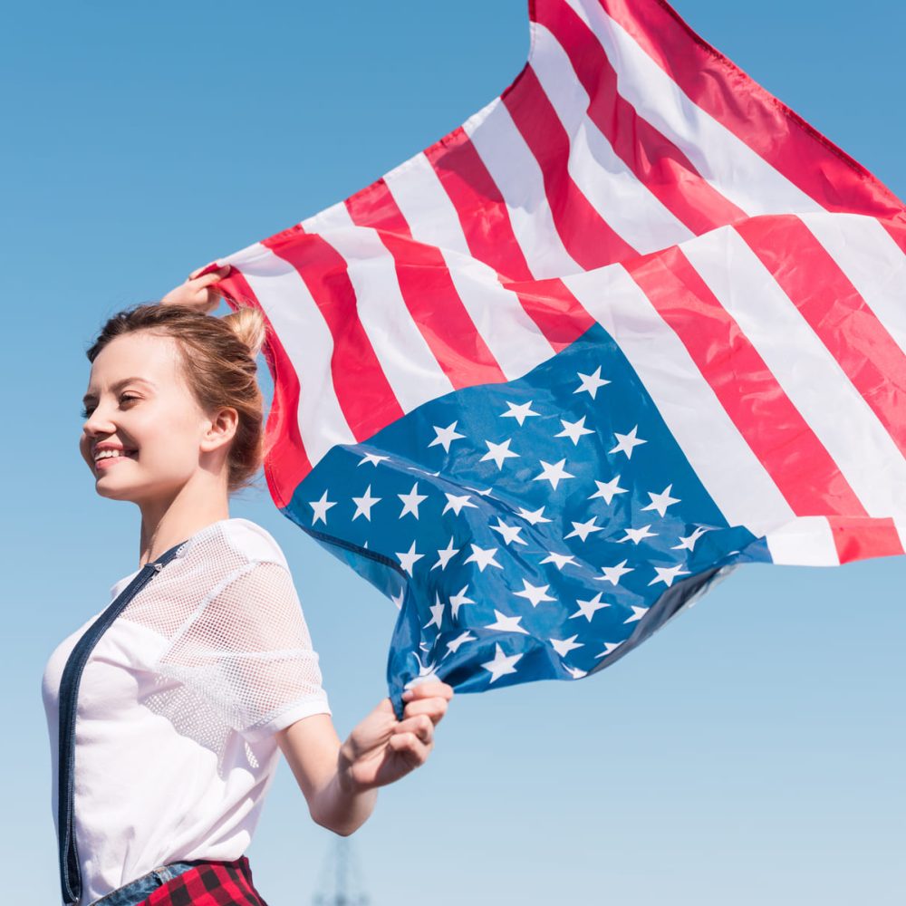 happy-young-woman-holding-united-states-flag-again-BESAKW2.jpg