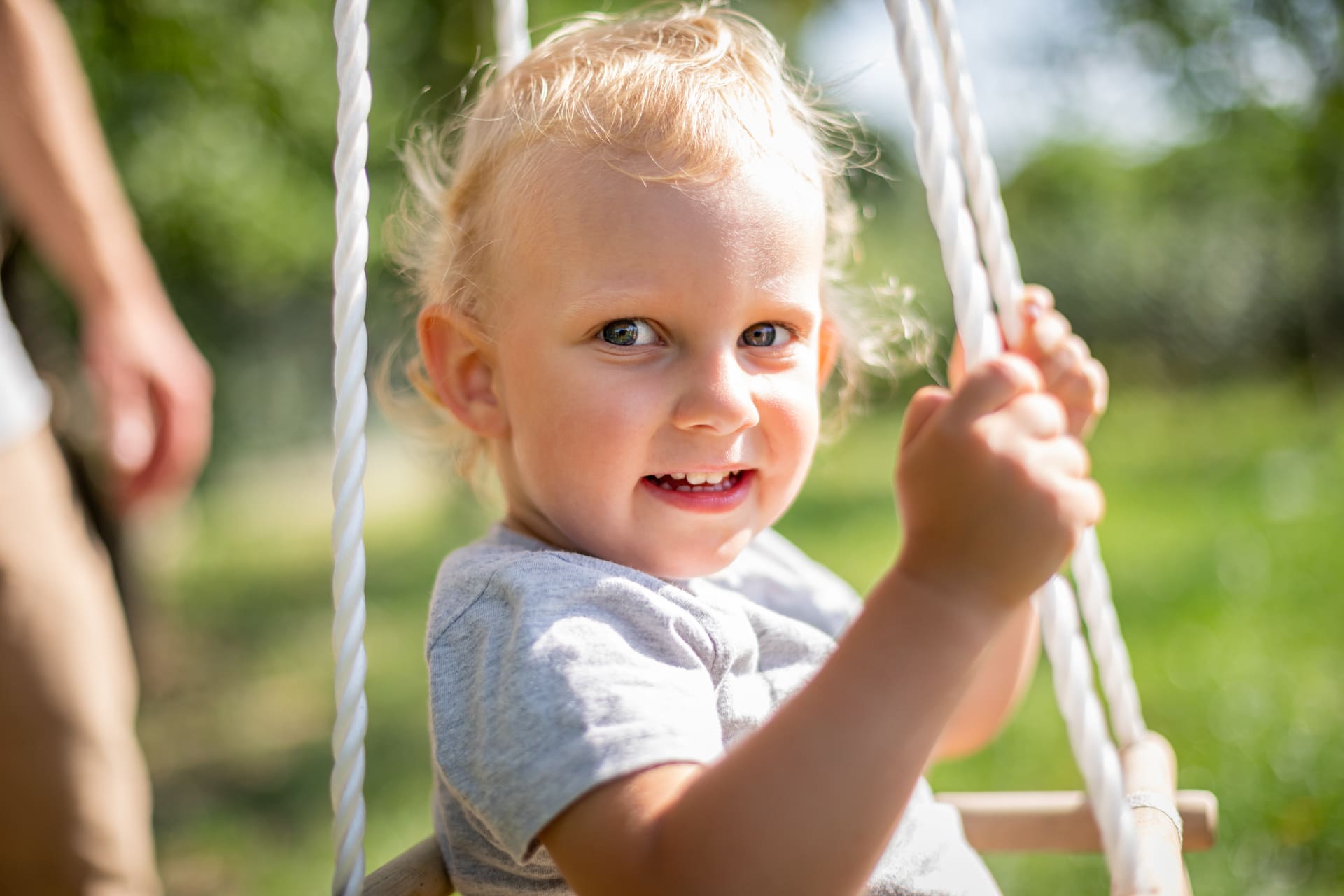 happy-small-child-sitting-in-baby-swing-outdoor-in-2H22QFU.jpg